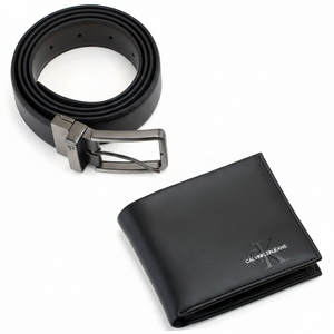 Detailed close-up of the brown side of a Calvin Klein reversible leather belt showing the embossed genuine leather stamp and polished metal pin buckle