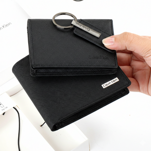 Handheld view of the Calvin Klein men's accessory gift set, including a black saffiano leather wallet, a slim card holder, and a silver-accented keychain