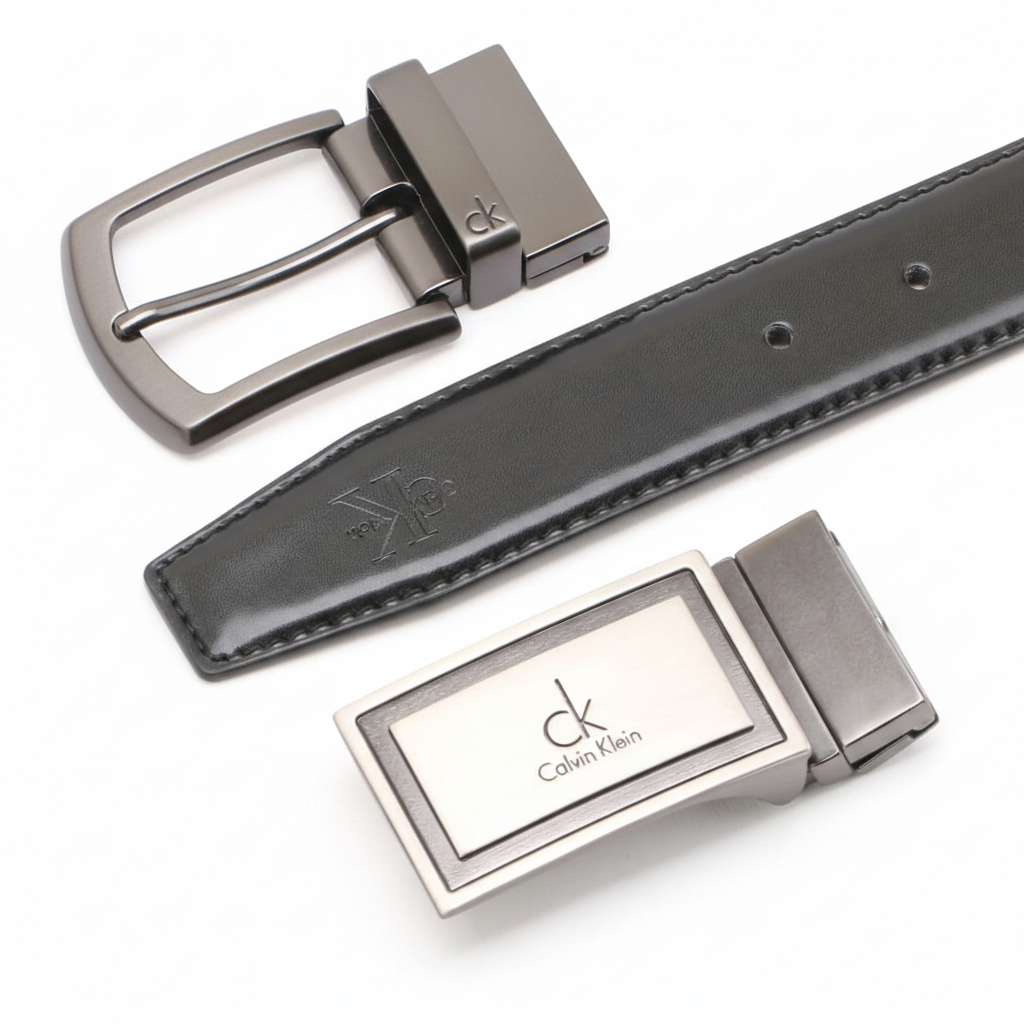 High-detail close-up of two Calvin Klein metal buckles showing the embossed brand logo on the black leather strap and the polished gunmetal hardware finish