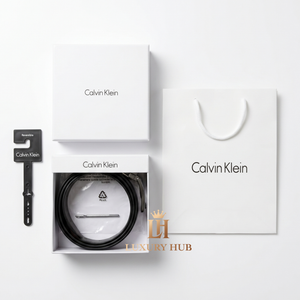 Top view product photography of Calvin Klein reversible leather belt presented in its signature white gift box