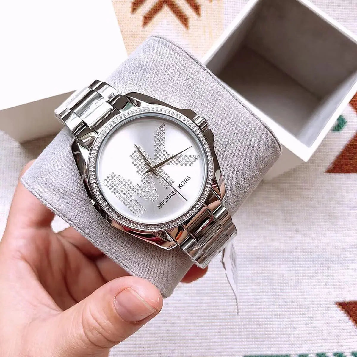 لقطة قريبة جداً لمينا ساعة MK6554 وتناسق اللون السيلفر مع لوجو MK المرصع بالكريستال