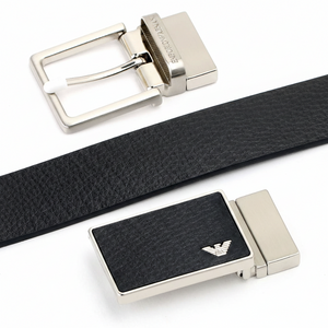 Close-up view of two premium Emporio Armani metal buckles: a modern plaque buckle with the iconic eagle logo and a classic pin buckle with engraved branding