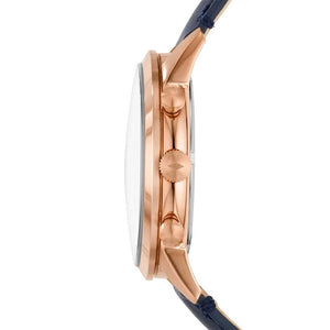 Side profile of a wristwatch with a rose gold case, a clear crystal, and a dark navy blue leather strap on a white background.