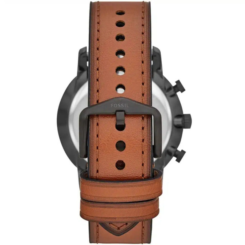 A close-up rear view of a watch with a brown leather strap and a dark gunmetal-tone case, showing the buckle and the Fossil logo on the metal loop.