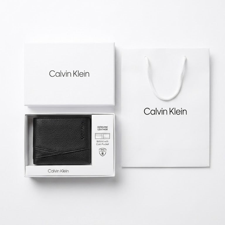 Flat lay presentation of the Calvin Klein mirror original saffiano leather wallet with original packaging white gift box and shopping bag