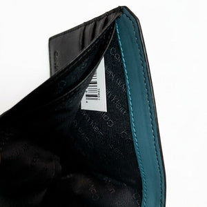 Detailed view of the Calvin Klein mirror original wallet sitting in the custom white insert inside the gift box showing branding details