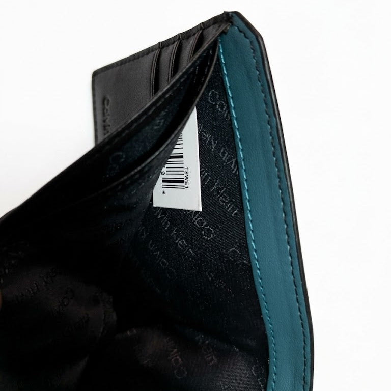 Detailed view of the Calvin Klein mirror original wallet sitting in the custom white insert inside the gift box showing branding details