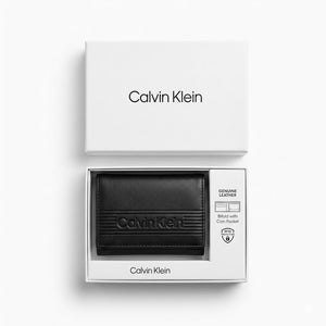 Top-down studio photograph of the Calvin Klein smooth black leather trifold wallet presented inside its open premium white gift box