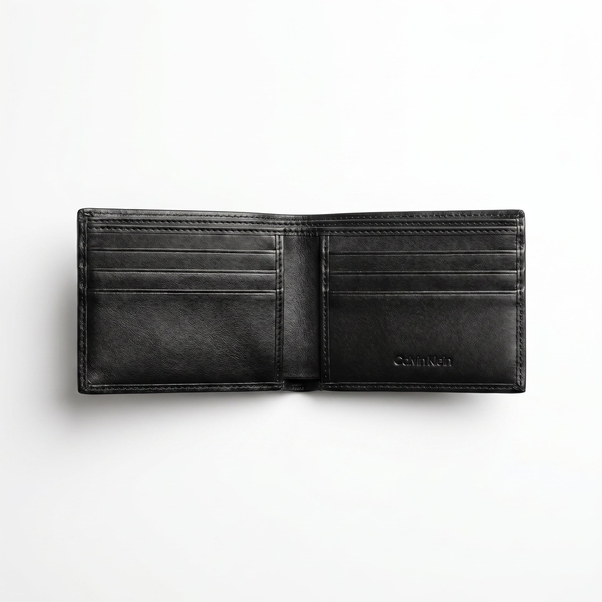 Top-down studio photograph of the Calvin Klein smooth black leather trifold wallet presented inside its open premium white gift box