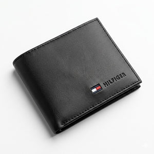 Professional angled studio photograph of the sleek Tommy Hilfiger mirror original smooth black leather bi-fold wallet