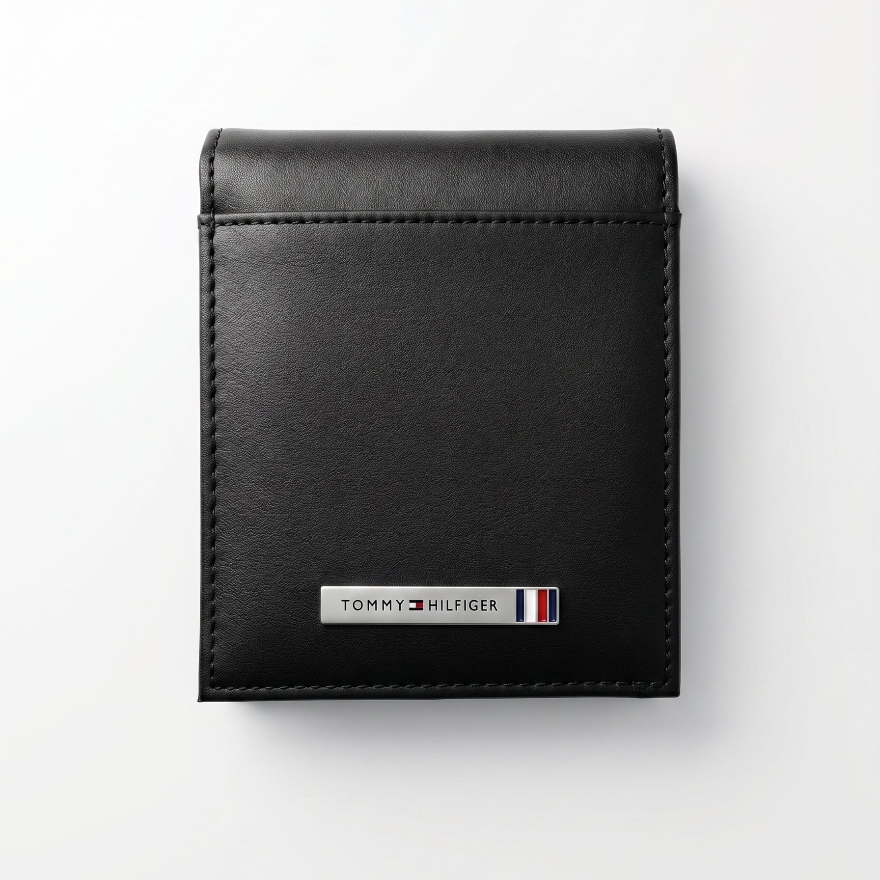 Straight front view product photography of the Tommy Hilfiger black smooth genuine leather wallet highlighting the silver metal bar logo