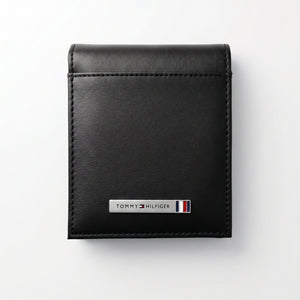 Straight front view product photography of the Tommy Hilfiger black smooth genuine leather wallet highlighting the silver metal bar logo