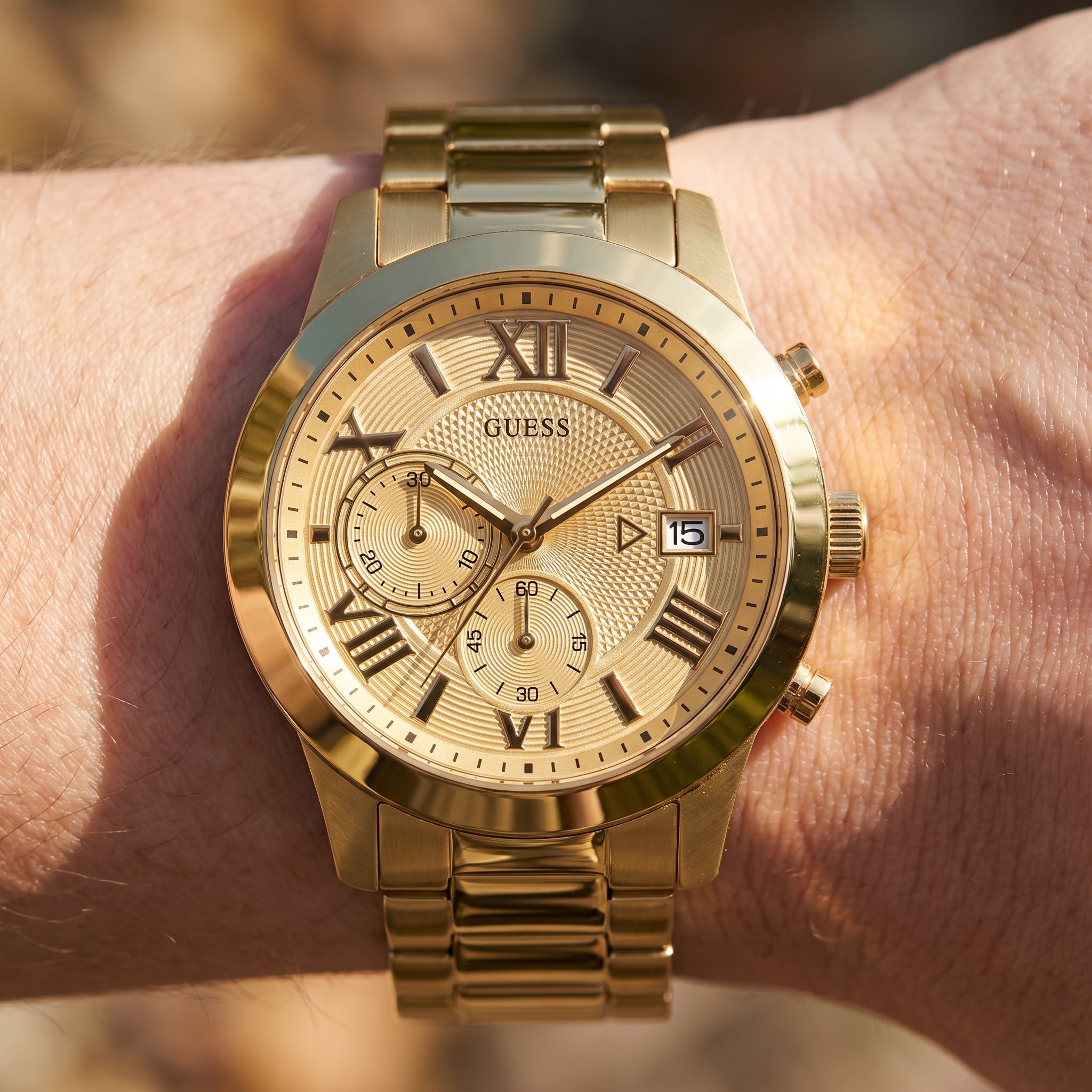 Wrist shot of Guess Atlas W0668G4 watch showing the gold metal band