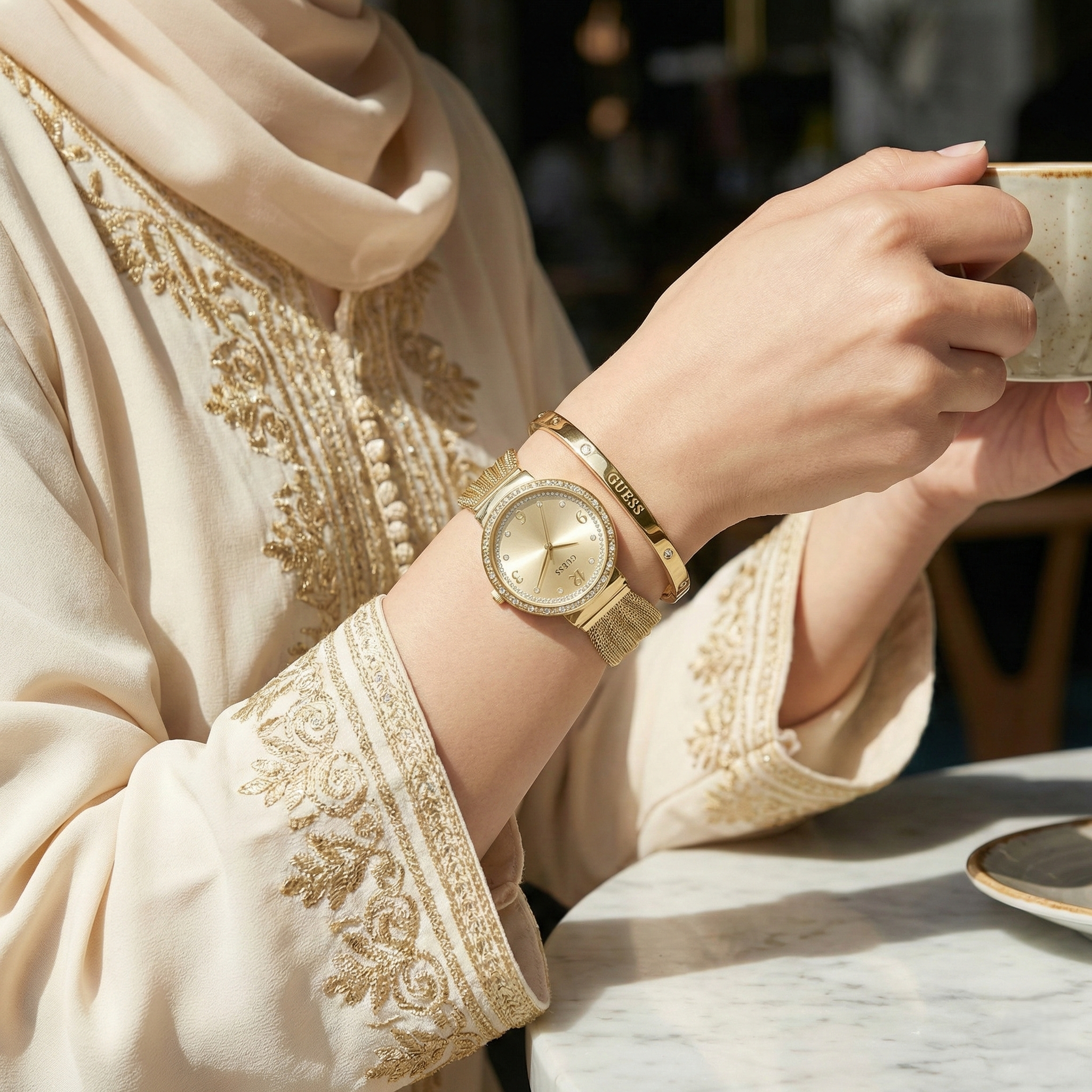 Woman wearing Guess Chiffon W1083L2 gold watch with an evening gown