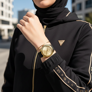 Woman wearing Guess Cubed GW0665L1 gold and black watch with a casual chic outfit