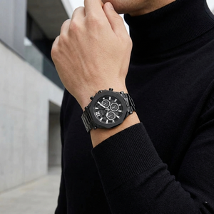 Male model wearing Guess Edge GW0539G3 full black watch with a sharp monochrome outfit