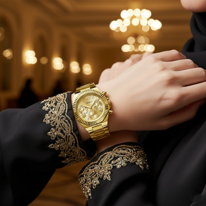 Elegant hijabi woman wearing Guess Equality GW0769L2 gold watch with a luxurious fabric cuff visible