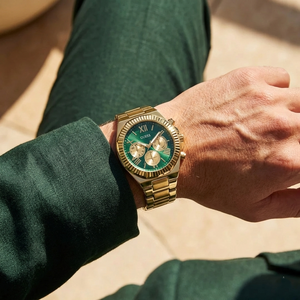 Man wearing Guess Equity GW0703G2 gold and green watch with a business suit