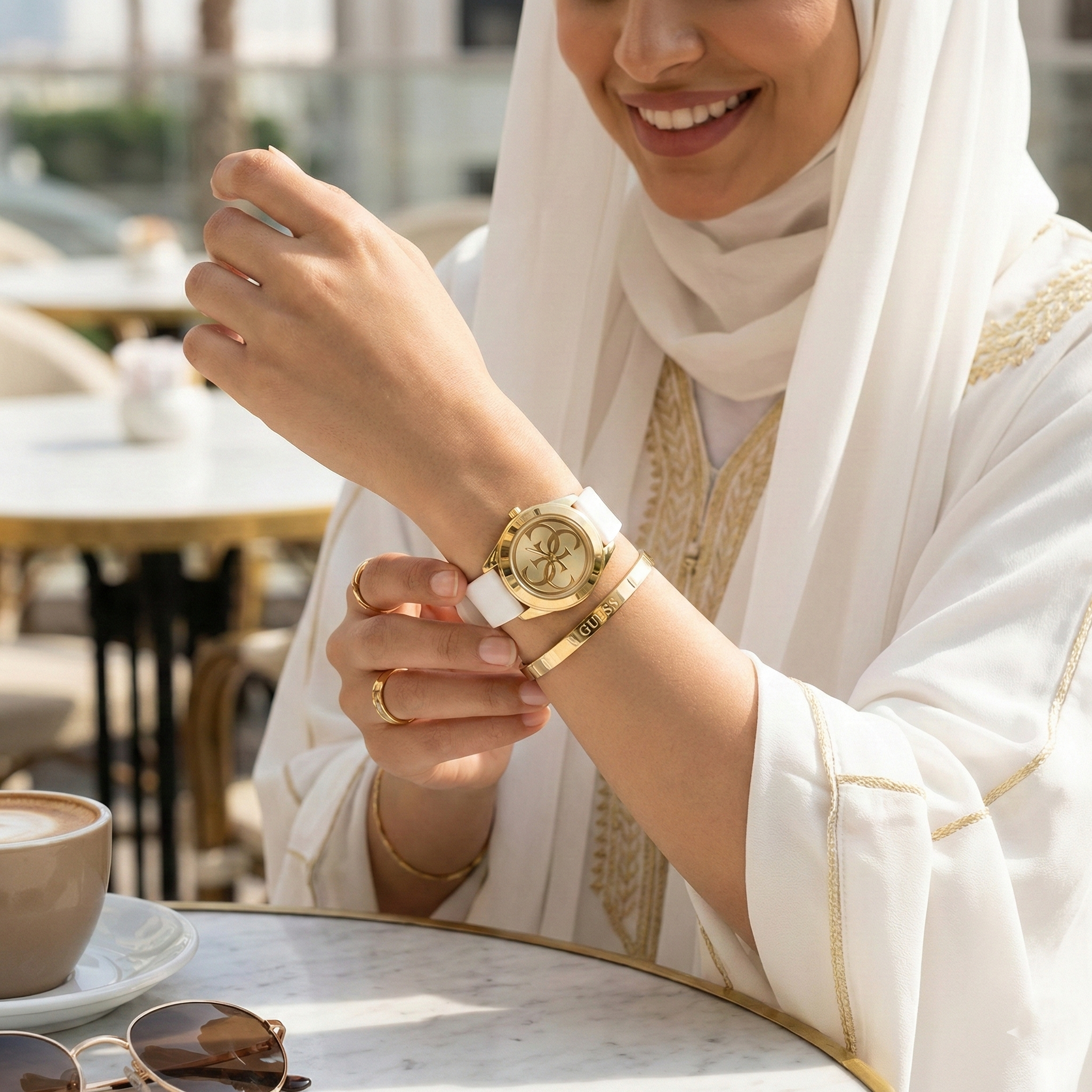 Female model wearing Guess G-Twist W0911L7 gold and white watch with a fresh summer outfit