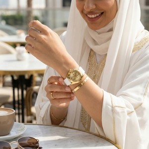 Female model wearing Guess G-Twist W0911L7 gold and white watch with a fresh summer outfit