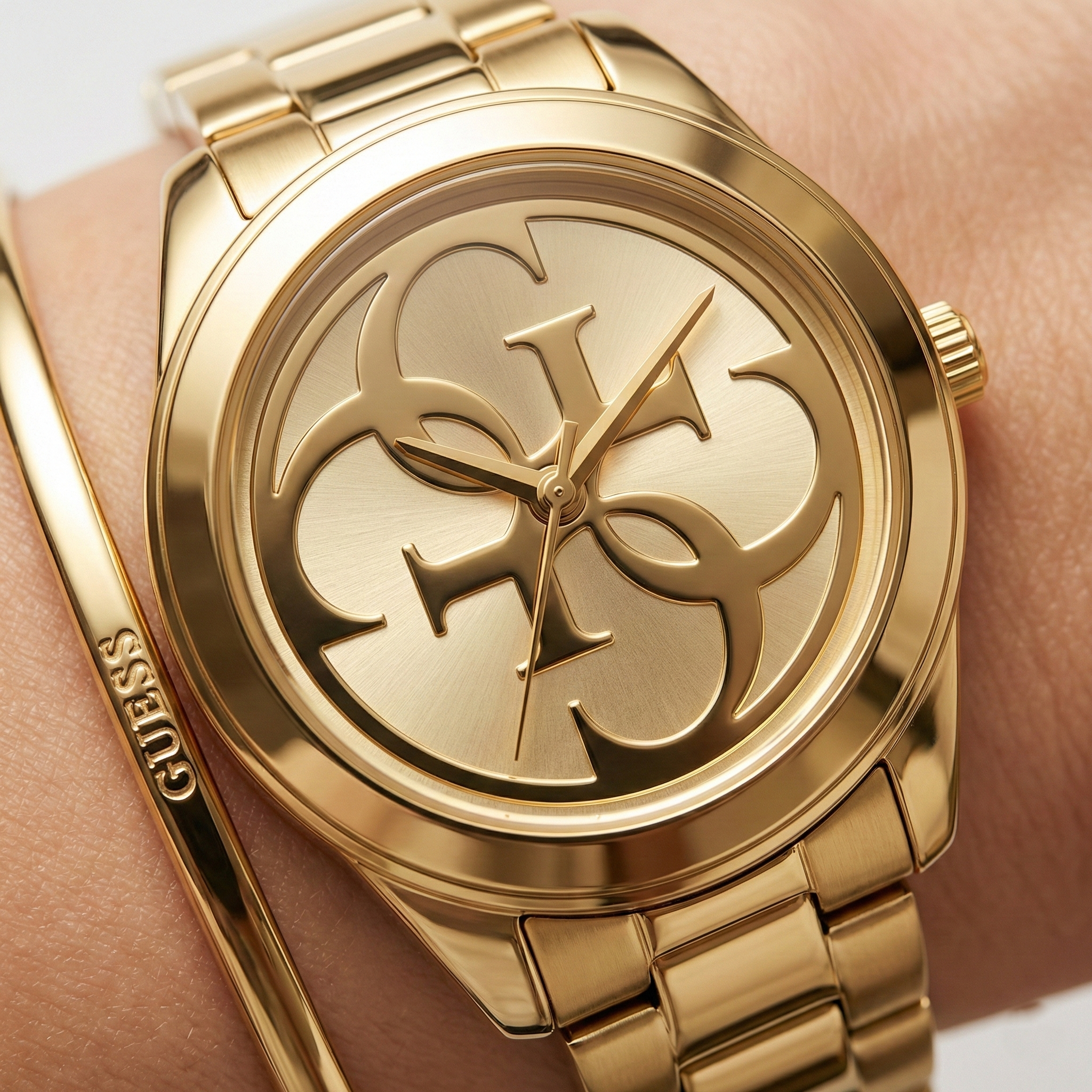 Close up shot of Guess W1082L2 watch on wrist showing the gold sunray dial and logo details