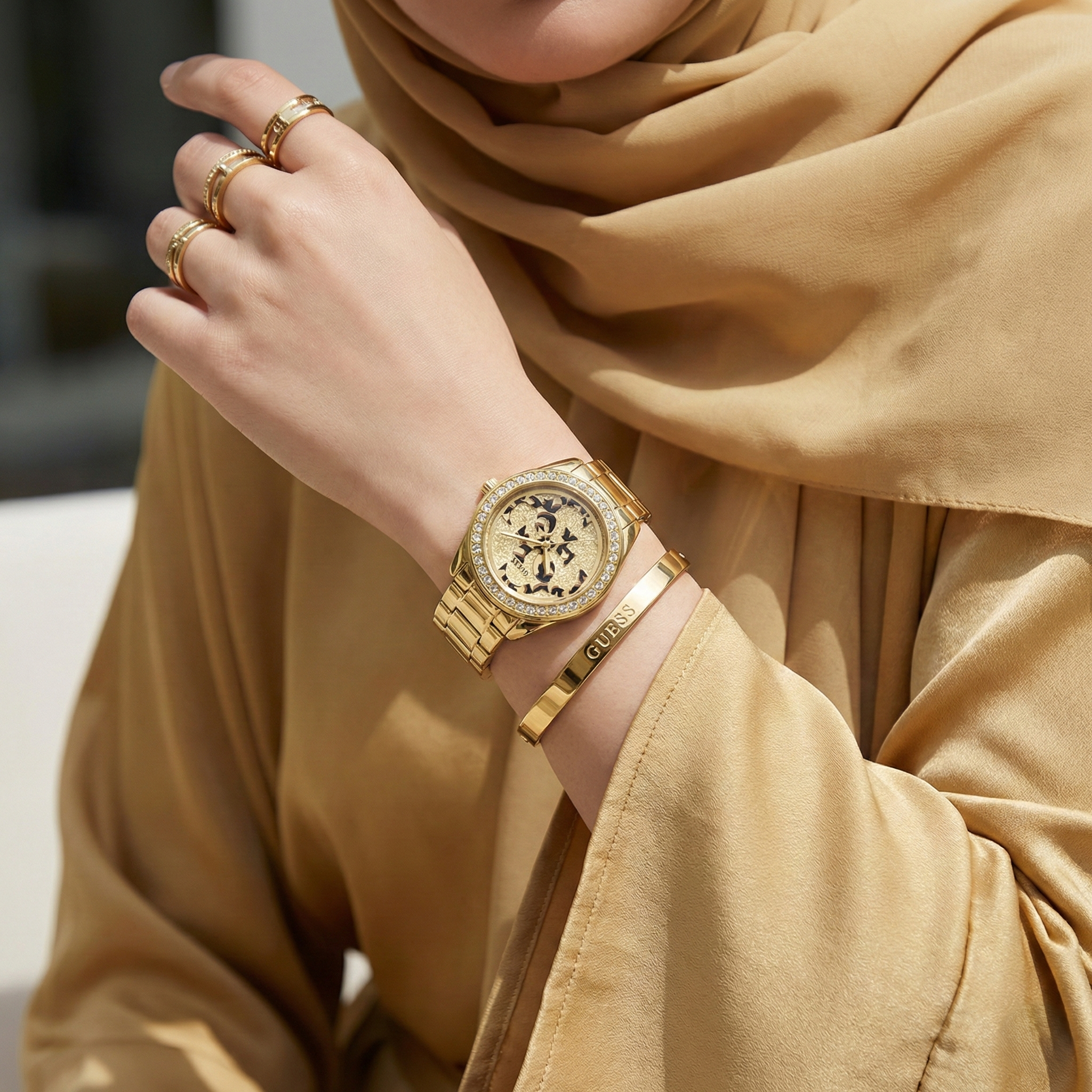 Female model wearing Guess G Twist W1201L2 gold watch with a glamorous party outfit