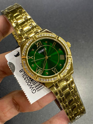 Real-life photo of Guess Cosmo GW0033L8 watch showing actual gold shine and green color