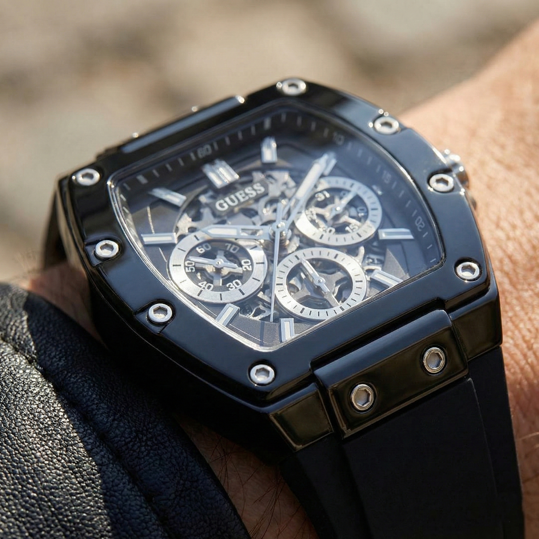 Close up shot of Guess GW0203G3 on wrist highlighting the black skeleton dial and silver hands
