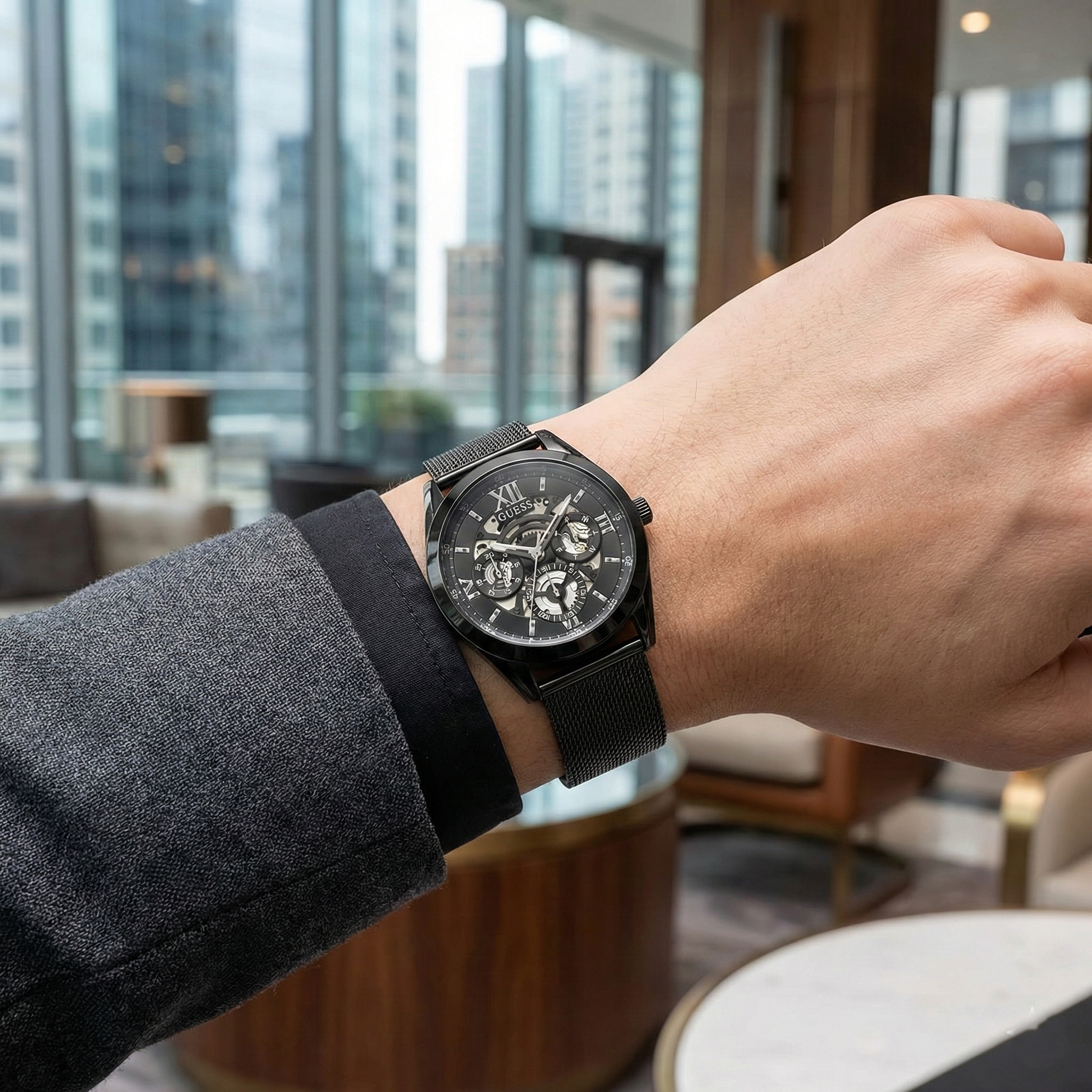AI lifestyle shot of a man wearing the Guess GW0368G3 all-black mesh watch