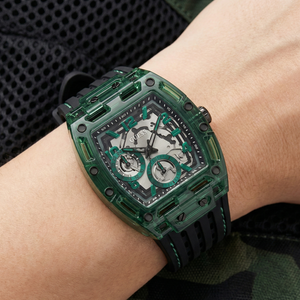 Detailed close-up of the skeletonized dial and green case of Guess GW0499G7