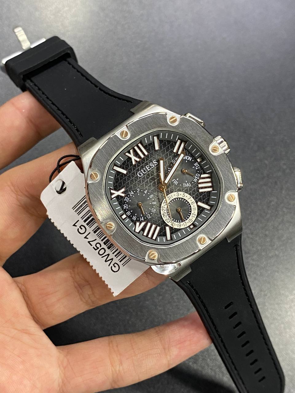Authentic real-life photo of the Guess GW0571G1 watch showing actual silver shine and black dial texture