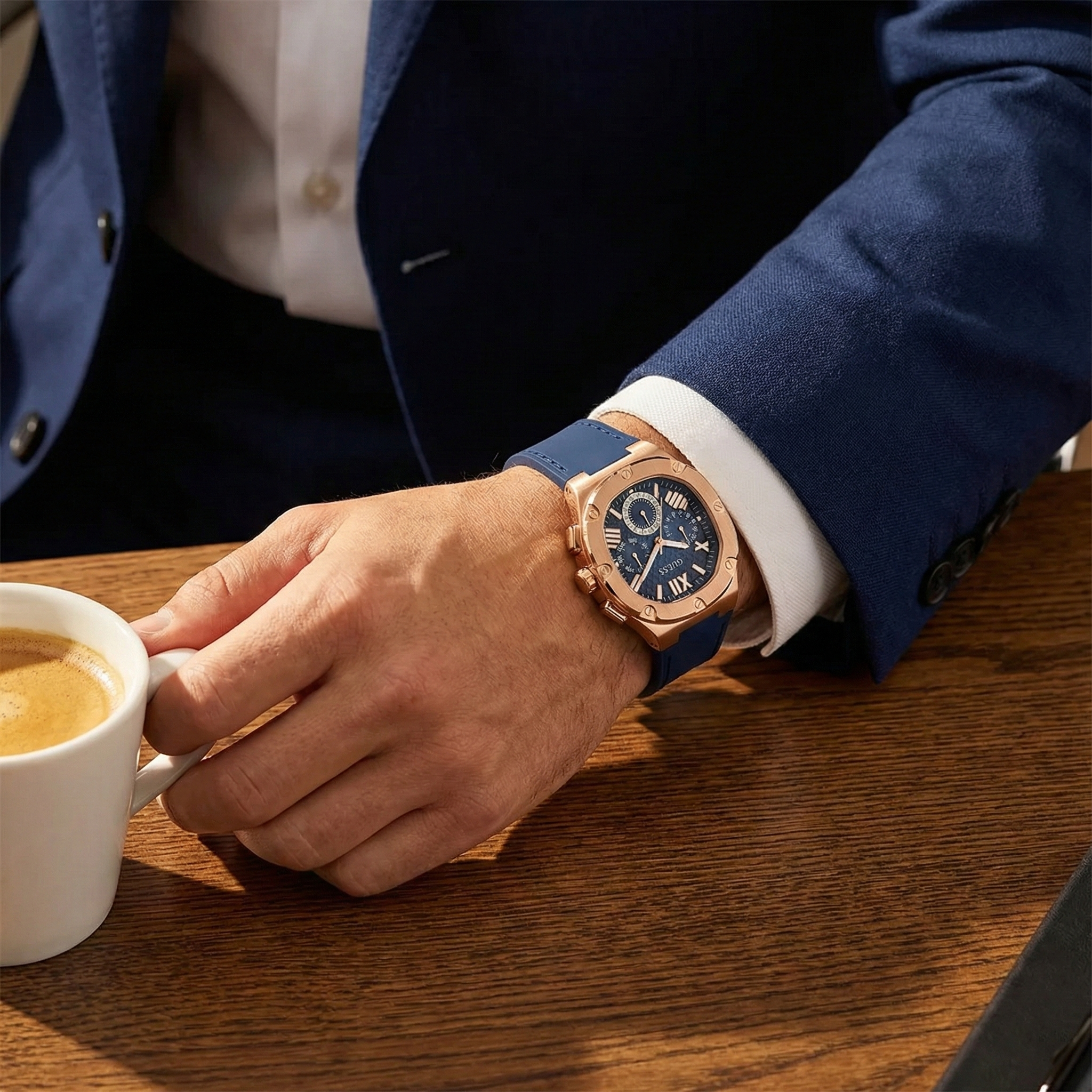 Male model wearing Guess GW0571G2 rose gold and navy rubber watch with a smart modern outfit