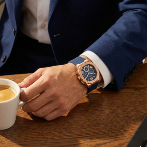 Male model wearing Guess GW0571G2 rose gold and navy rubber watch with a smart modern outfit