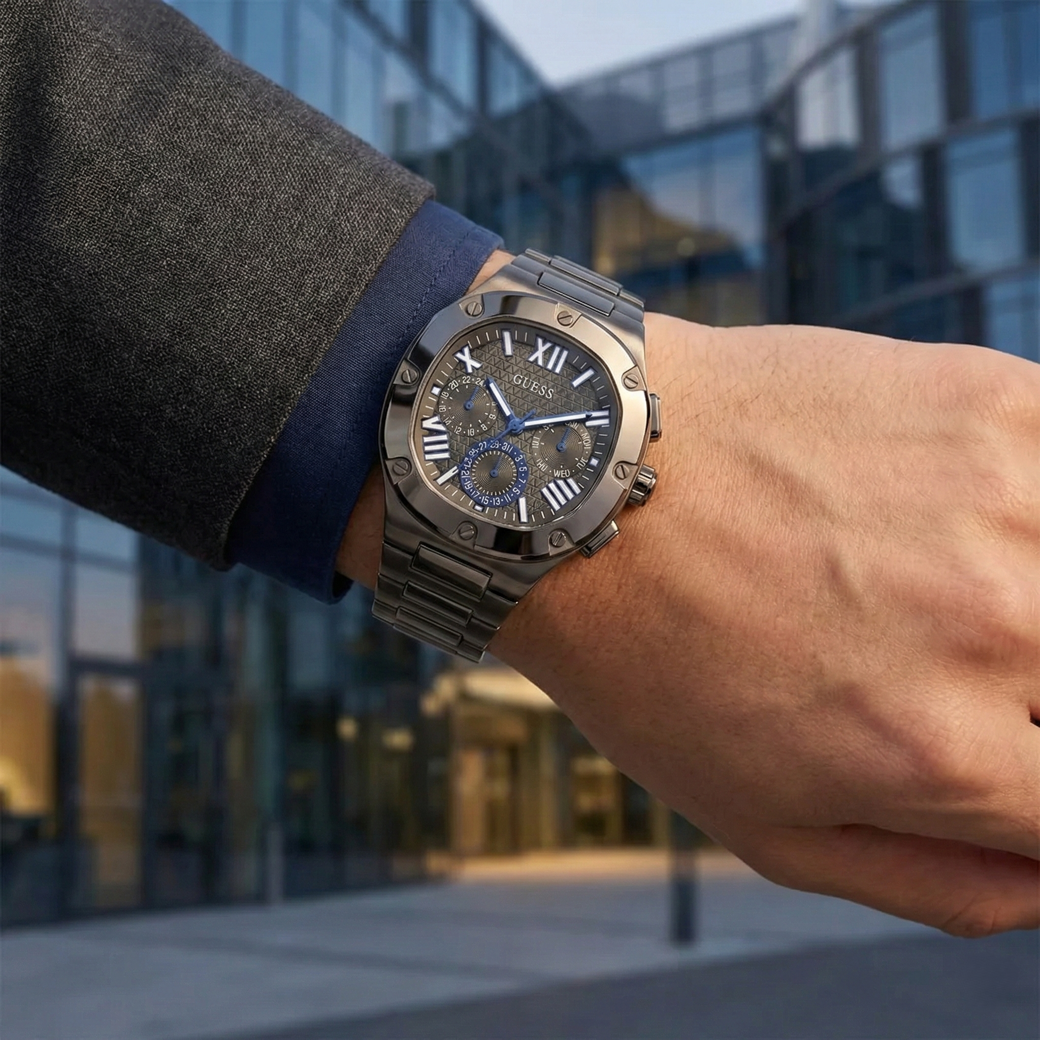 AI lifestyle shot of a man wearing the modern gunmetal Guess Headline watch