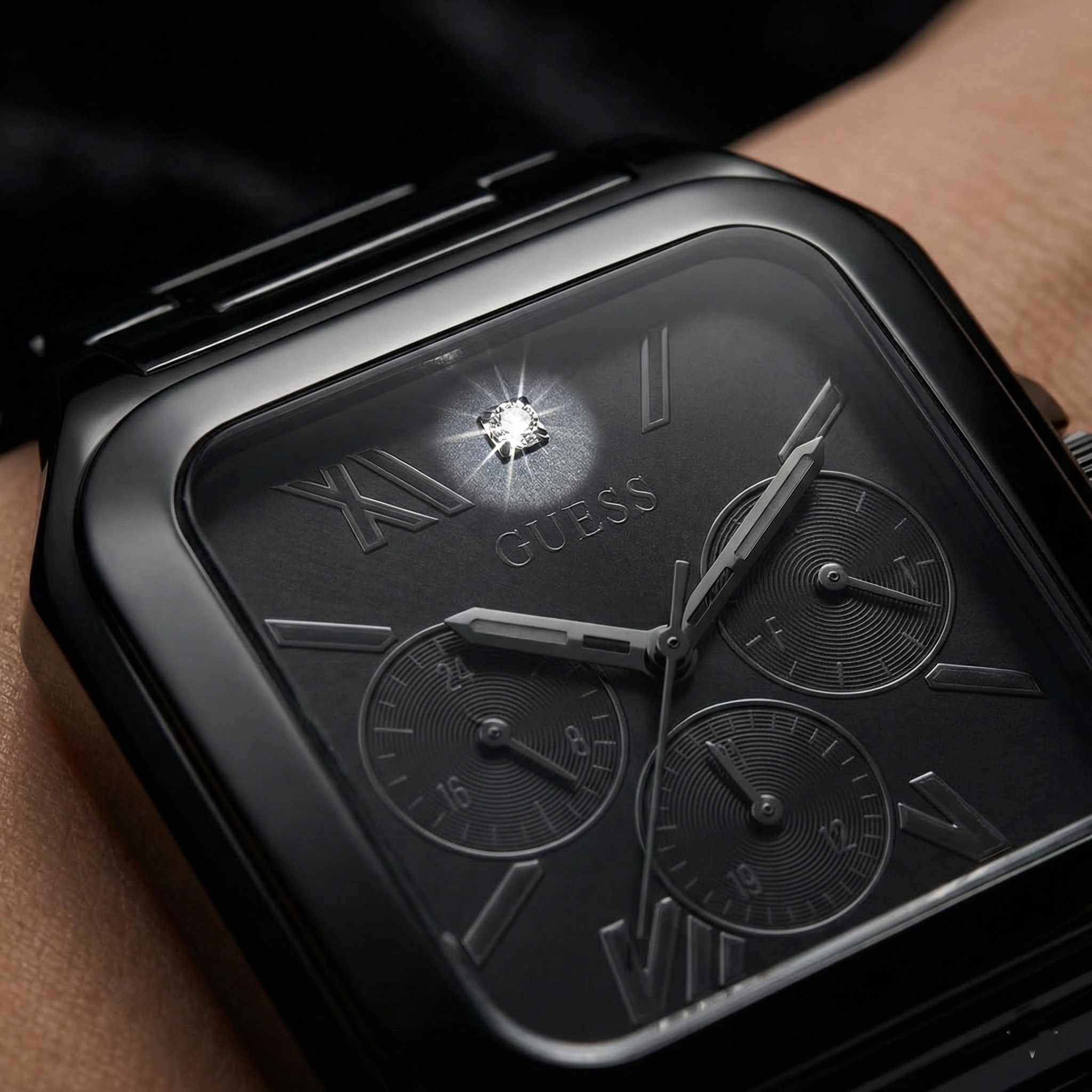 Close up shot of Guess GW0631G2 watch on wrist showing the black square dial and tonal sub-dials