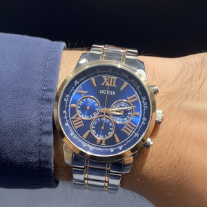 Close up shot of Guess Horizon W0379G7 watch on wrist showing the blue sunray dial and rose gold roman numerals