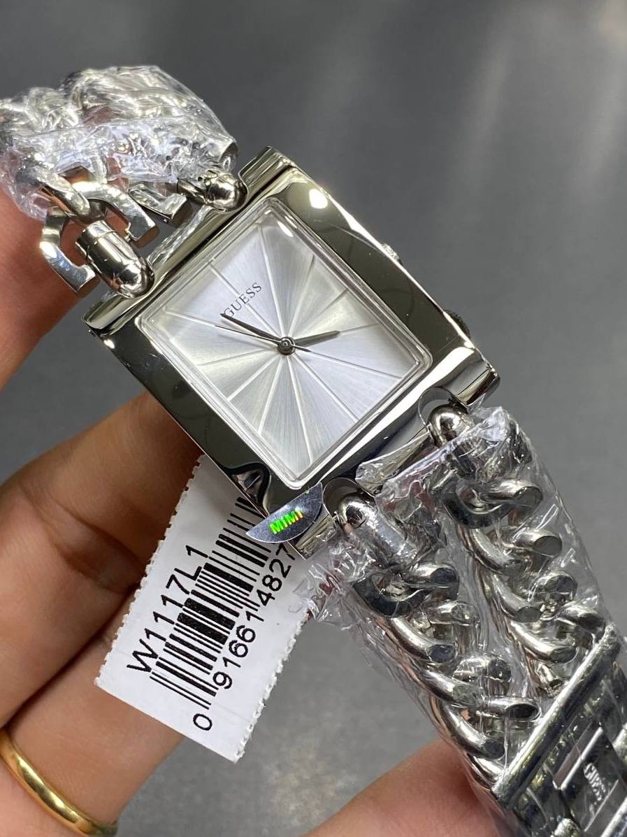 Authentic real-life photo of the Guess Mod Heavy Metal W1117L1 watch showing actual silver finish and tag details