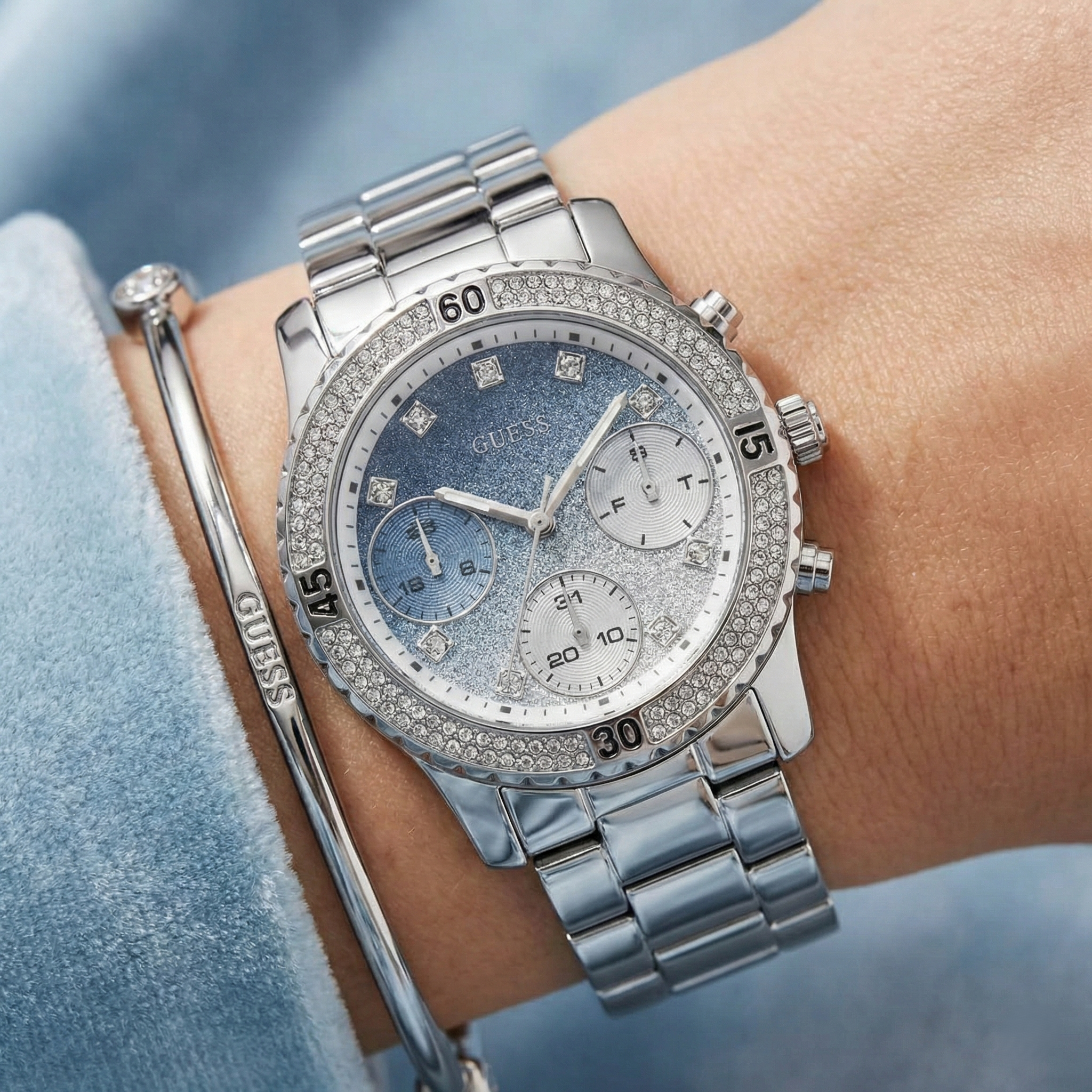 Close-up of Guess Confetti W0774L6 showing the blue glitter gradient dial and crystals