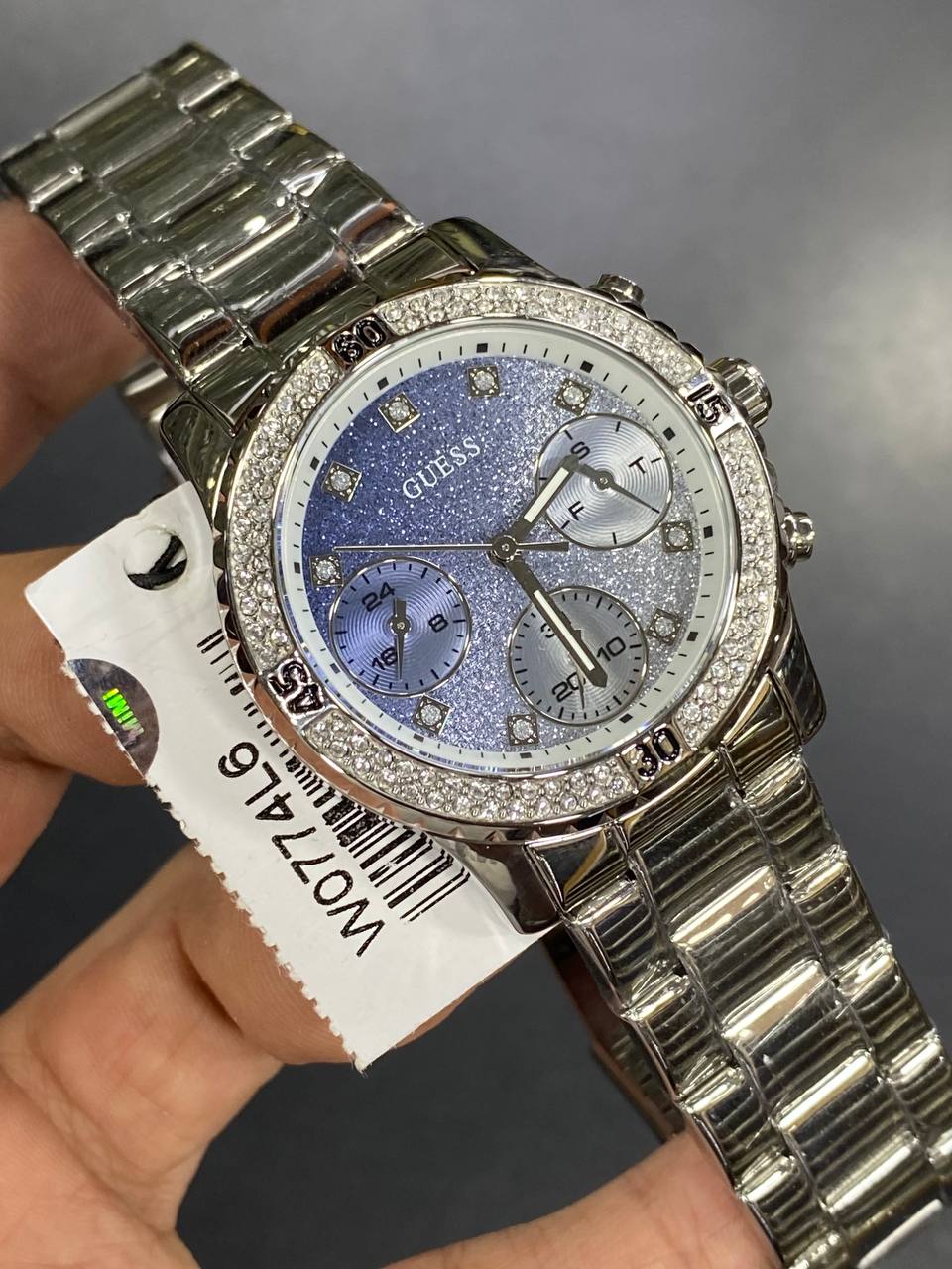 Real-life photo of Guess Confetti W0774L6 watch showing actual shine and glitter