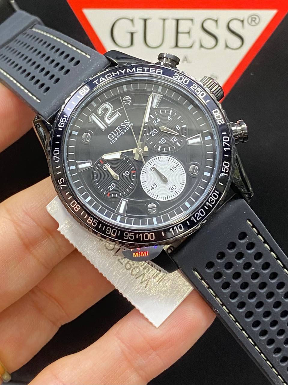 4. Angled view of Guess W0971G1 showing the matte black tachymeter bezel and side pushers