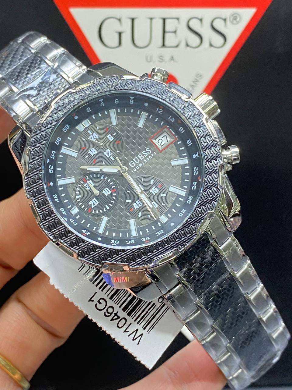 Authentic real-life photo of the Guess W1046G1 showing actual silver steel shine and black dial texture in Egypt