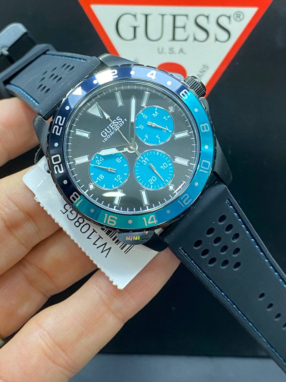 Authentic real-life photo of the Guess W1108G5 showing actual black matte finish and blue pop color in Egypt