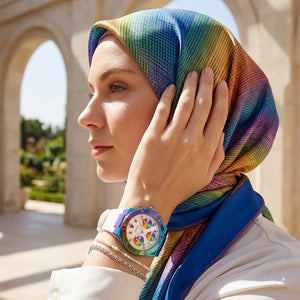 Elegant woman wearing Guess Athena GW0030L6 women's quartz battery watch with multicolor case and luxury white rubber strap