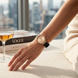 Close up of Guess Cosmo GW0034L1 women's quartz battery watch on wrist showing gold sunray dial and luxury crystal bezel