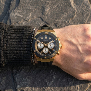 Close up of Guess Poseidon GW0057G1 men's quartz battery watch on wrist showing deep black dial and luxury black bezel