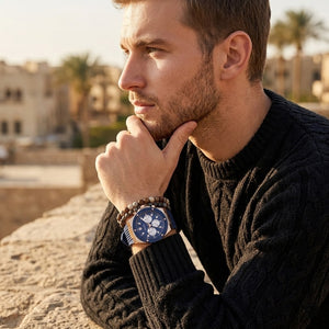 Elegant man wearing Guess Poseidon GW0057G2 men's quartz battery watch with rose gold case and luxury navy blue rubber strap