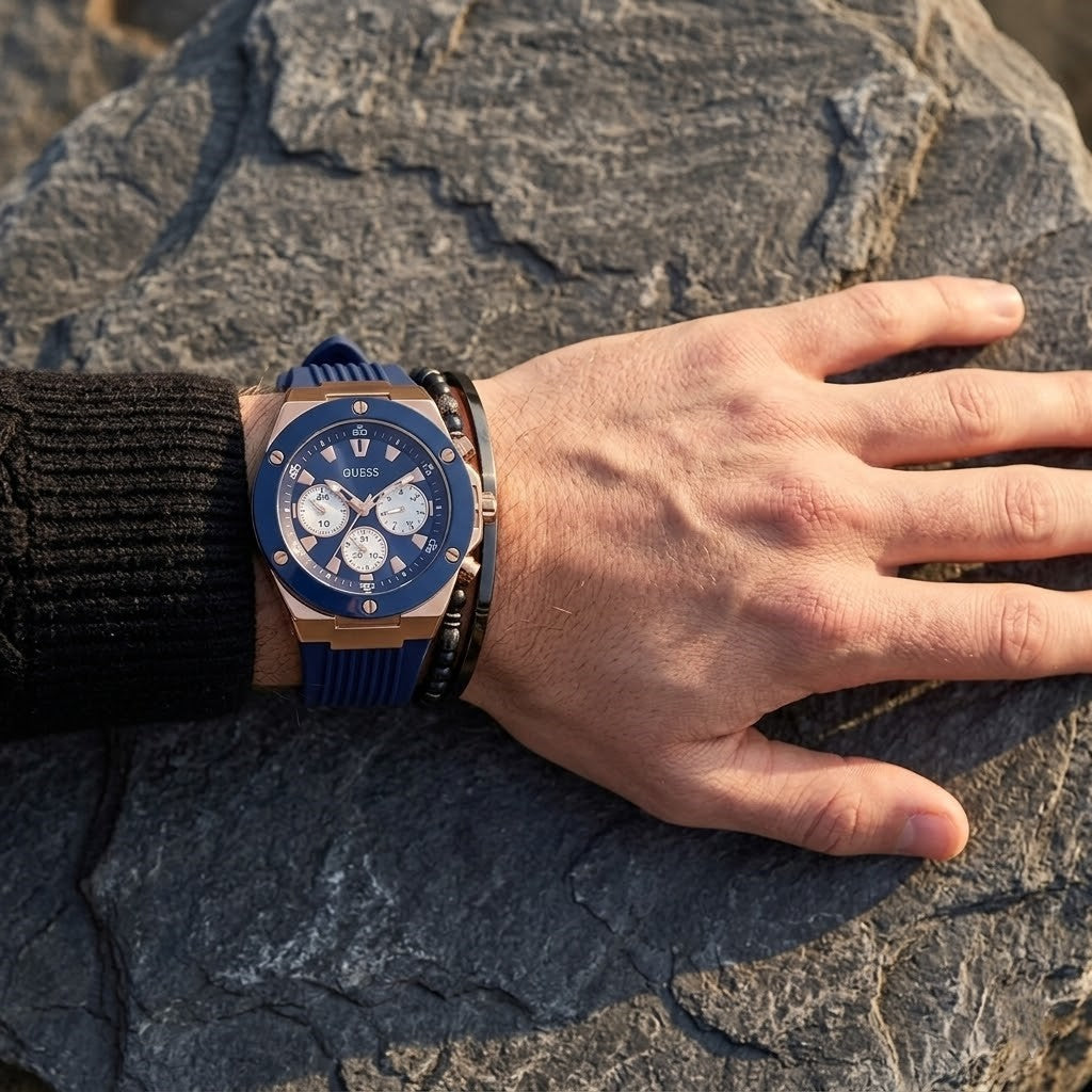Close up of Guess Poseidon GW0057G2 men's quartz battery watch on wrist showing deep blue dial and luxury blue bezel
