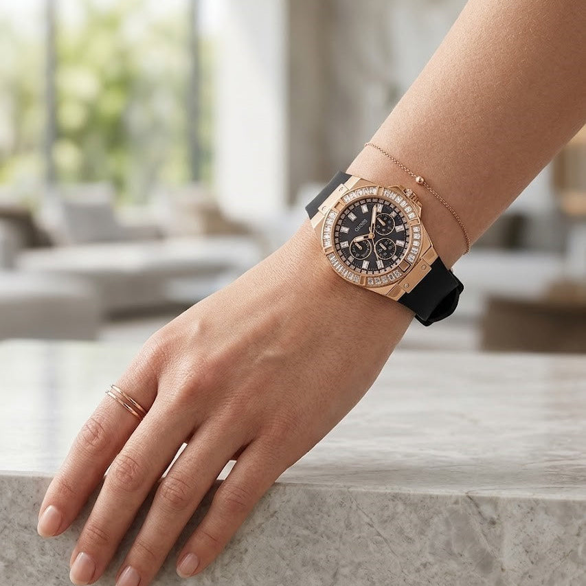 Close up of Guess Venus GW0118L2 women's quartz battery watch on wrist showing black mother of pearl dial and luxury baguette crystal bezel