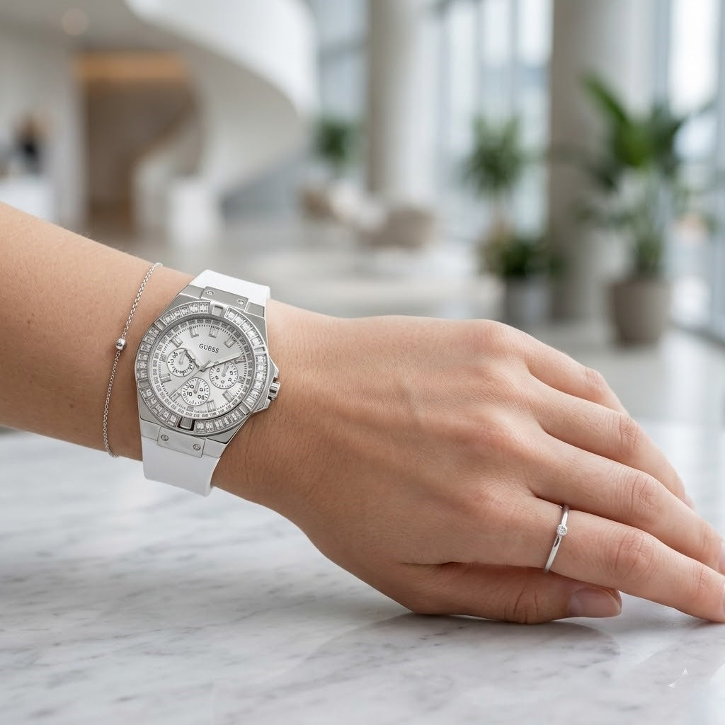 Close up of Guess Venus GW0118L3 women's quartz battery watch on wrist showing clean white dial and luxury baguette crystal bezel