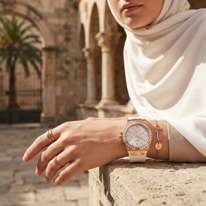 Elegant woman wearing Guess Venus GW0118L4 women's quartz battery watch with rose gold case and luxury white rubber strap